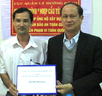 Ông Nguyễn Đức Hùng (trái) trao số tiền ủng hộ xây dựng cầu treo dân sinh cho Cục QLĐB III