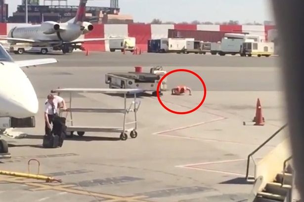 một nhân viên sân bay tập chống đẩy ngay trên đườn