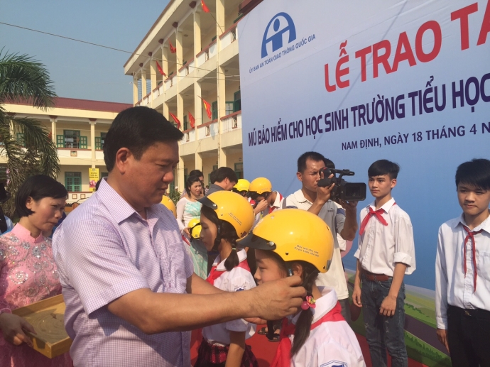 Bộ trưởng Đinh La Thăng trao mũ cho học sinh trườn