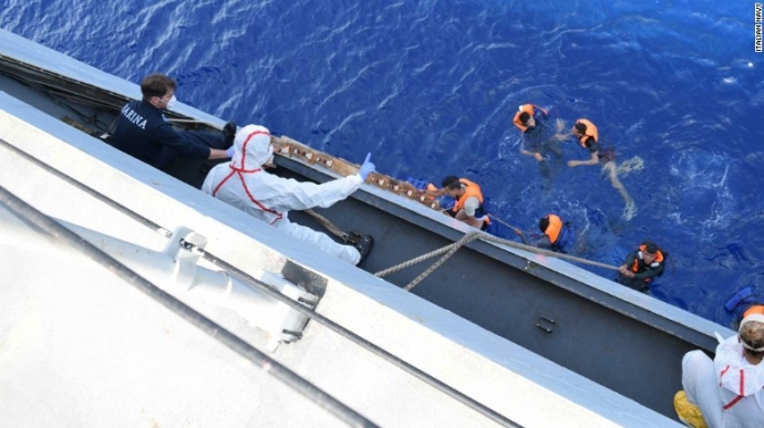 Người tị nạn bám vào thang dây để leo lên tàu hải 