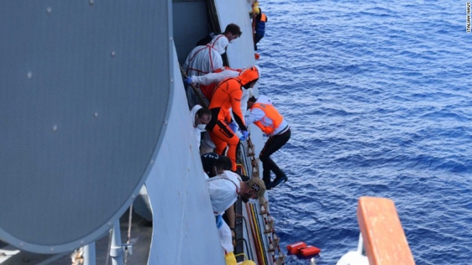 Người tị nạn bám vào thang dây để leo lên tàu hải 