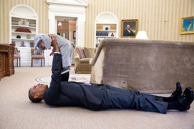 Ông Obama nằm lăn dưới đất, chơi đùa với con gái c