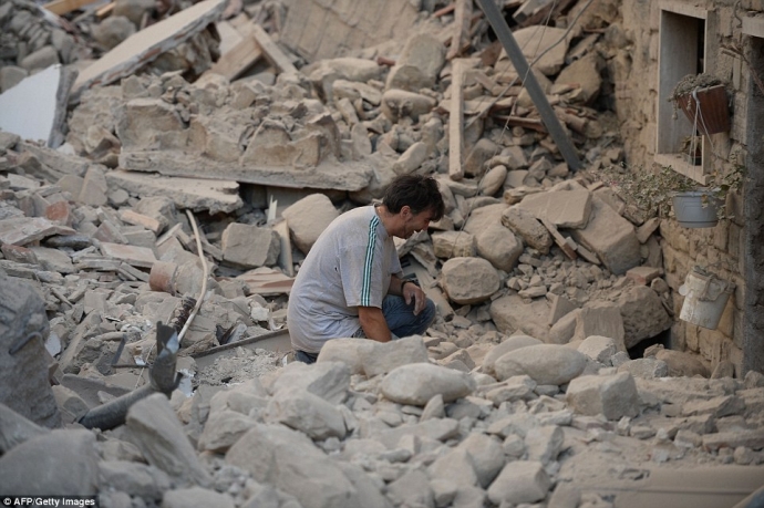 Cư dân trong khu vực động đất quỳ khóc trước đống 