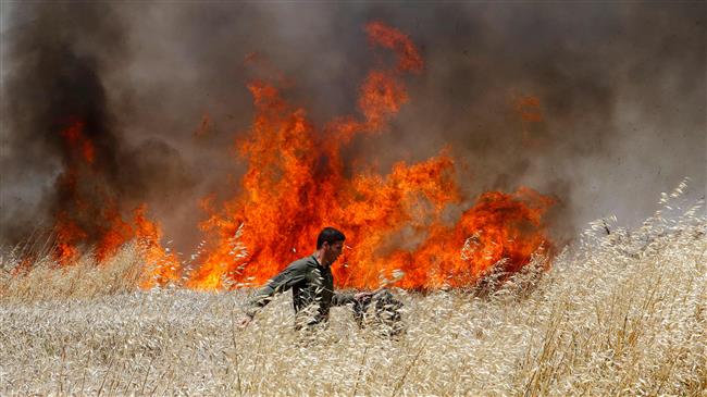 Một binh lính Israel cố gắng dập lửa lớn trên cánh