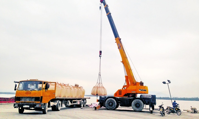 Loading cement onto vehicles for export to INDONESIA.