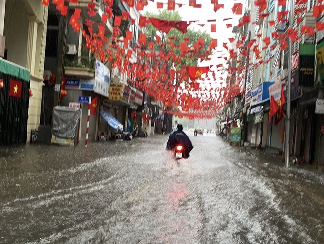 Hà Nội: Nhiều tuyến đường ngập nặng, người dân lội nước đi chợ, đi làm- Ảnh 1. Hà Nội: Nhiều tuyến đường ngập nặng, người dân lội nước đi chợ, đi làm- Ảnh 1.