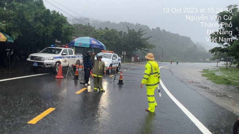 Đội mưa ph&acirc;n luồng, ngăn phương tiện qua điểm sạt lở đ&egrave;o Hải V&acirc;n - Ảnh 1.