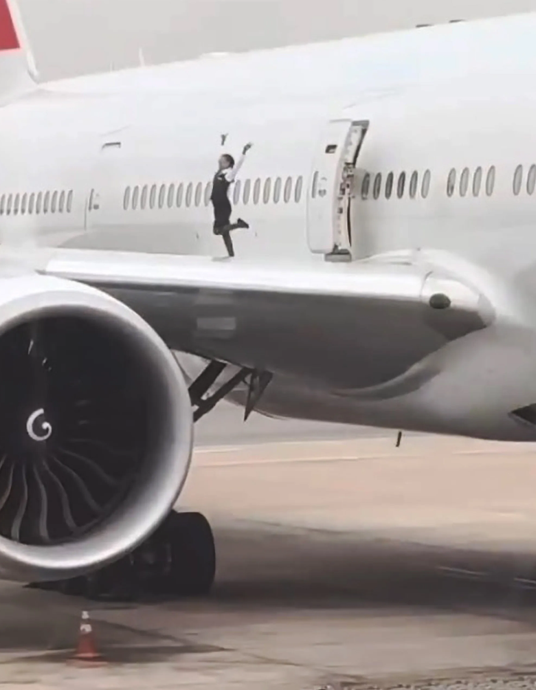 Hai tiếp vi&ecirc;n h&agrave;ng kh&ocirc;ng leo l&ecirc;n c&aacute;nh m&aacute;y bay tạo d&aacute;ng chụp ảnh - Ảnh 1.