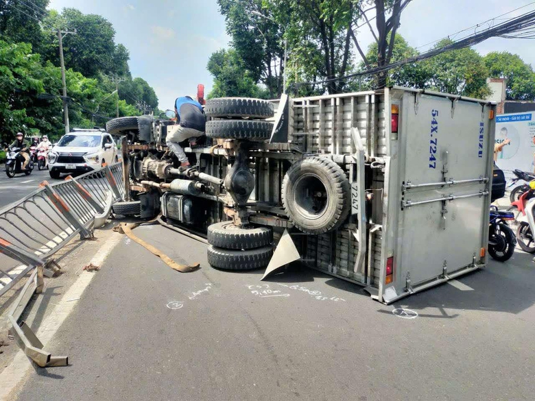 Xe tải t&ocirc;ng dải ph&acirc;n c&aacute;ch, lật ngang giữa đường ở TP.HCM- Ảnh 1.