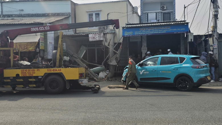 Taxi mất l&aacute;i t&ocirc;ng sập tường hai nh&agrave; b&ecirc;n đường tại quận 7, TP.HCM- Ảnh 1.