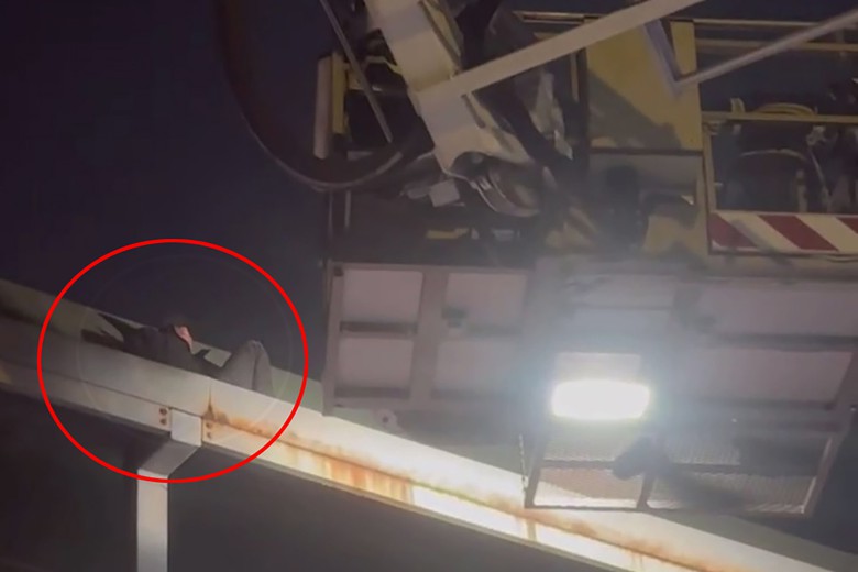 Giải cứu thanh ni&ecirc;n uống rượu bia, nằm tr&ecirc;n m&aacute;i cầu vượt đi bộ- Ảnh 1.