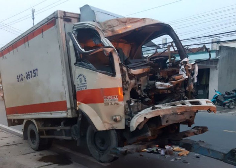 Sau va chạm đầu xe tải bị bẹp d&uacute;m, t&agrave;i xế bị kẹt cứng trong cabin.