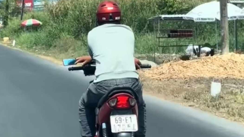 Người đàn ông thản nhiên bắt chéo tay điều khiển xe máy trên quốc lộ 1- Ảnh 1. Người đàn ông thản nhiên bắt chéo tay điều khiển xe máy trên quốc lộ 1- Ảnh 1.