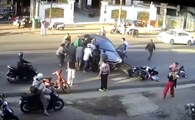 Người d&acirc;n hợp sức n&acirc;ng &ocirc; t&ocirc; để cứu nạn nh&acirc;n. (Ảnh cắt từ clip)