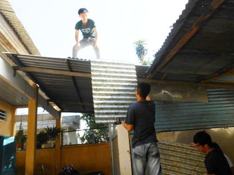 C&aacute;c t&igrave;nh nguyện vi&ecirc;n lớp m&aacute;i trường bằng tấm lợp sinh th&aacute;i l&agrave;m từ 1,5 triệu vỏ hộp sữa