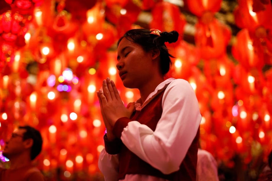 Một cô gái đang thắp hương cầu khấn tại đền Wat Mangkon vào khoảnh khắc Giao thừa (Phố Trung Quốc ở Băng Cốc, Thái Lan). (Ảnh: Reuters)