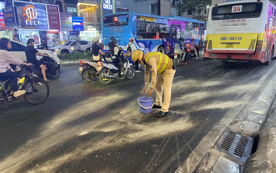 Ô tô buýt sập hố ga, dầu chảy lênh láng khiến nhiều người đi xe máy trượt ngã ở Hà Nội- Ảnh 2.