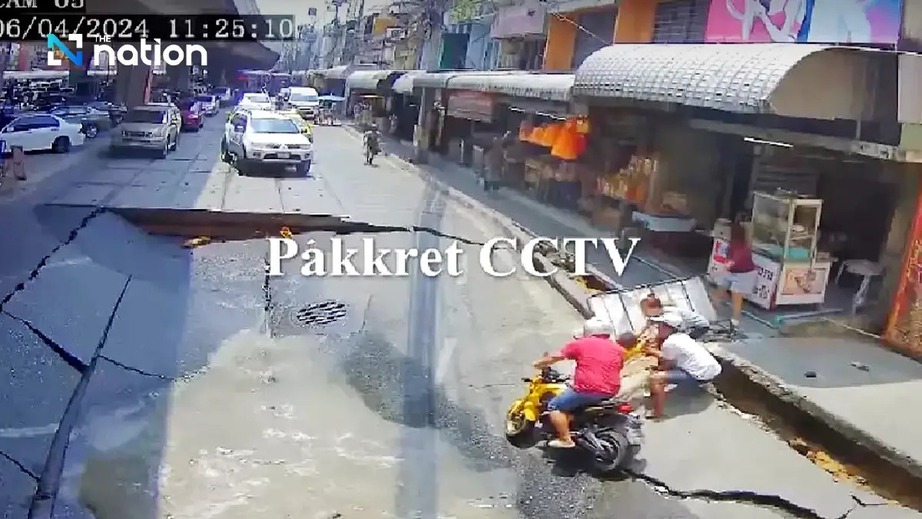 Camera an ninh ghi lại khoảnh khắc hai cha con đi xe máy gặp nạn ngay lúc đoạn đường bị sụt lún, tạo thành hố tử thần khổng lồ. (Ảnh: The Nation Thailand)