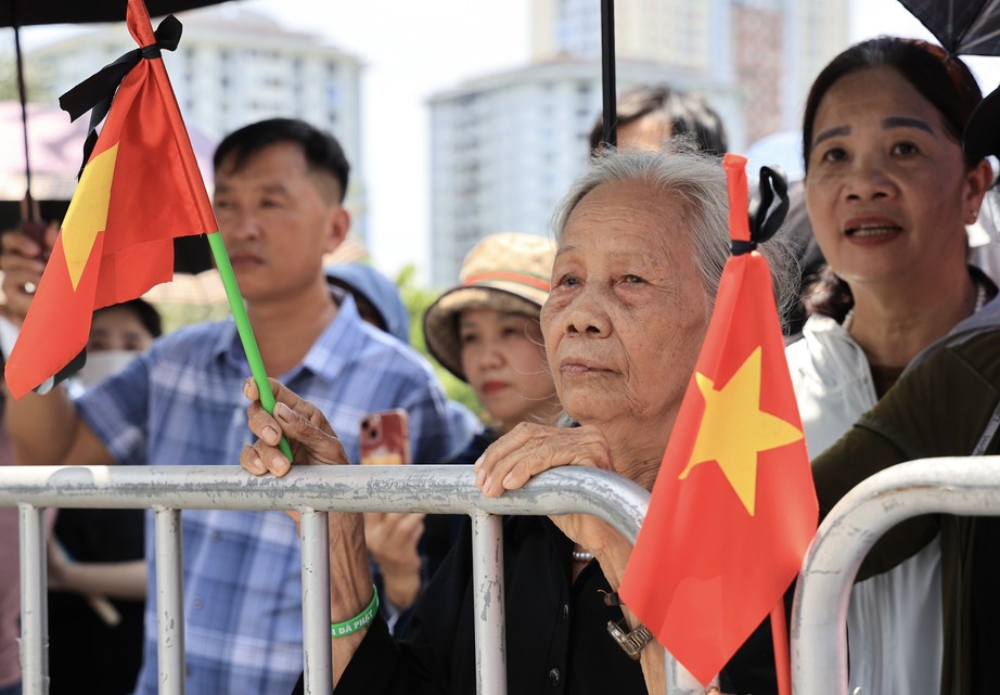 Người dân đội nắng đứng ven đường chờ tiễn biệt Tổng Bí thư về nơi an nghỉ - Ảnh 1.