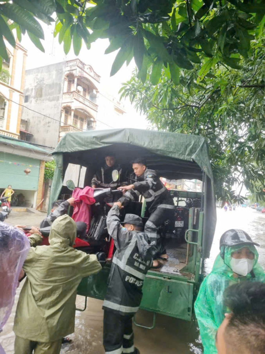 Công an Hà Nội dầm mưa phân luồng, hỗ trợ người dân qua vùng ngập- Ảnh 7.