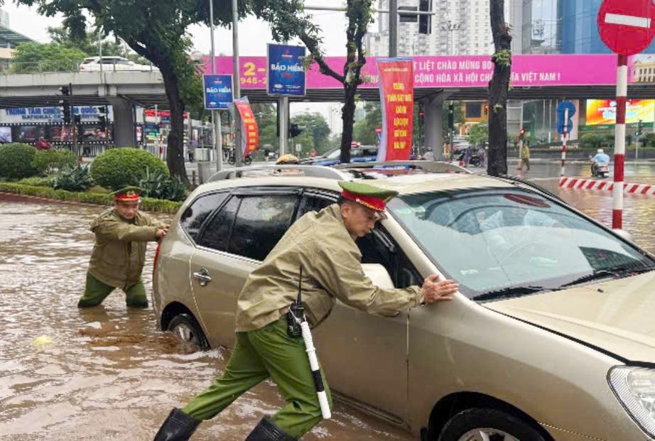 Công an Hà Nội dầm mưa phân luồng, hỗ trợ người dân qua vùng ngập- Ảnh 9.