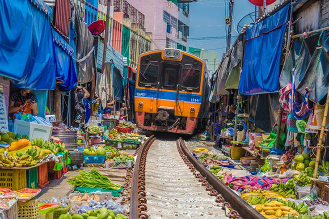 Tuyến đường sắt Maeklong ở Thái Lan thường đi qua khu chợ sầm uất này, những người bán hàng sẽ di chuyển hàng hóa của họ ra khỏi đường xe lửa và bê trở lại khi tàu đã chạy qua.