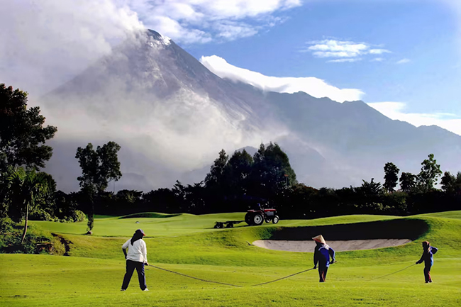 The Volcanic One - Merapi Golf Club, Slemen, Indonesia: Mặc dù đây là một sân golf tuyệt đẹp nhưng đừng để vẻ bề ngoài đó lừa, bởi ngọn núi hùng vĩ ở phía sau chính là núi Merapi, một trong những ngọn núi lửa hoạt động mạnh nhất trên hành tinh. Chơi golf ở đây, bạn sẽ nhìn thấy khói cuồn cuộn trên đỉnh núi.