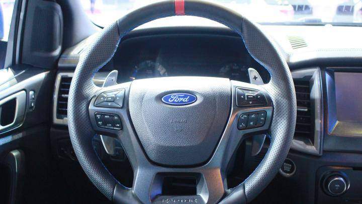 Vô-lăng Raptor bọc da, trang trí với chỉ khâu màu xanh, tích hợp lẫy chuyển số.