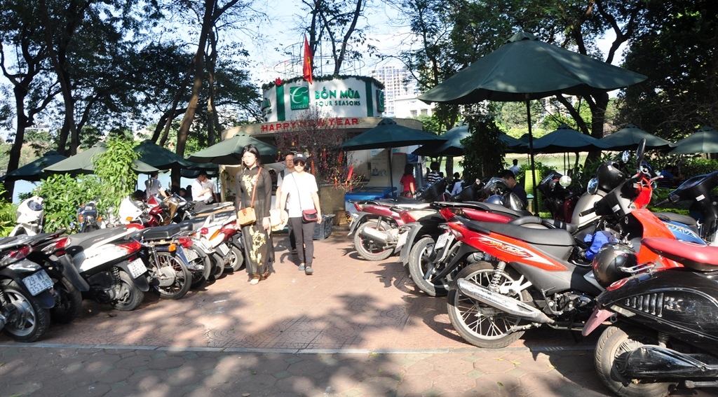 Xe đỗ trên vỉa hè dẫn vào một quán giải khát bên Hồ Hoàn Kiếm.