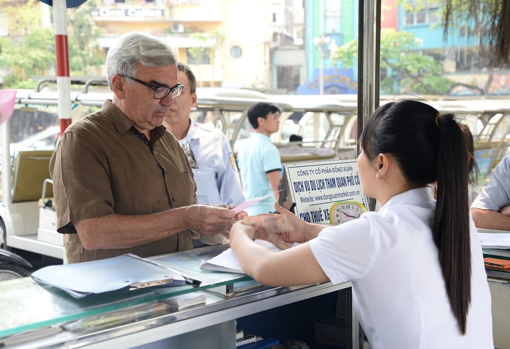 Khách nước ngoài mua vé tham quan phố cổ bằng xe ô tô điện vì giá rẻ lại đi được vào nhiều phố cổ hơn đi xích lô và đương nhiên tiện lợi, rẻ hơn xe ôm truyền thống.