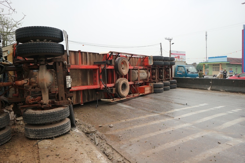 Cạnh đó là chiếc xe container bị lật nghiêng sau khi tông vào nhà dân