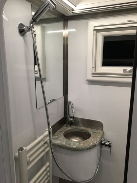 Nhà vệ sinh với vòi hoa sen, bồn rửa mặt, gương và bệt vệ sinh