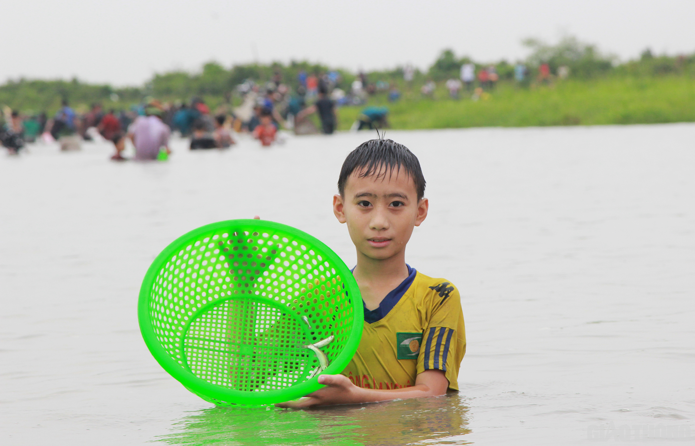 Nhiều cháu bé cũng theo bố mẹ, anh chị xuống đầm bắt cá với hi vọng may mắn sẽ đến với bản thân mình