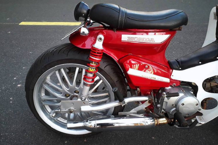 Trong khi đó, bánh sau có bộ gắp hoàn toàn mới, được gia công từ thép ống. Các tai bắt phuộc trên khung cũng đã được nới rộng. Ngay cả những chiếc mâm cũng đã được chủ xe tiện moay-ơ riêng để lắp được bánh lớn. Cặp moay-ơ này đồng thời là điểm bắt những đĩa phanh, nâng cấp hệ thống phanh đùm lên thành phanh đĩa an toàn hơn