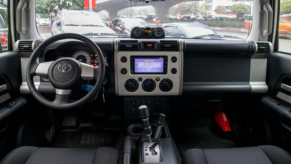 Vô-lăng trên Toyota FJ Cruiser mới là nhựa mềm, không được tích hợp bất cứ phím bấm chức năng nào, ngay sau đó là màn hình Analog dạng truyền thống