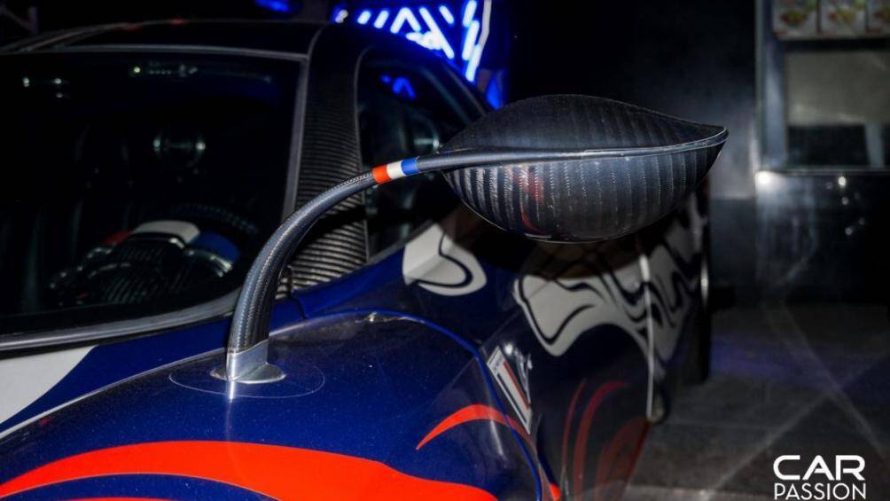 Phần đầu xe sử dụng màu xanh làm nền cho những hoa văn màu đỏ uốn lượn từ cản trước đến các vè bánh xe