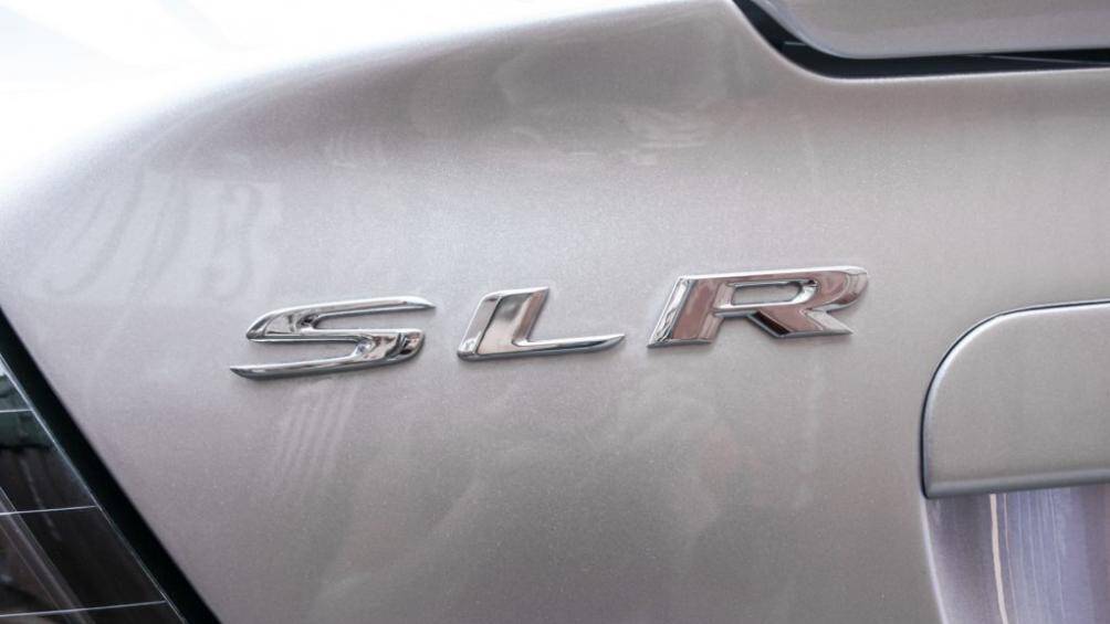 Bên góc trái là tên xe SLR bằng kim loại, SLR là chữ viết tắt của Sport Light Racing – mẫu xe đua thể thao có khối lượng nhẹ