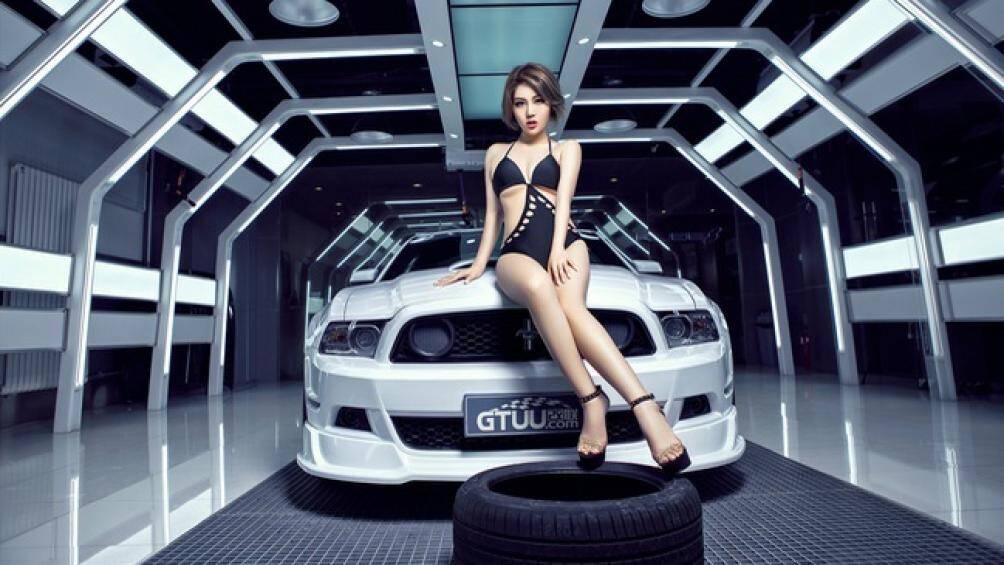 Người mẫu sở hữu khuôn mặt xinh xắn cùng body chuẩn ngồi trên nắp capo của "ngựa hoang" Ford Mustang