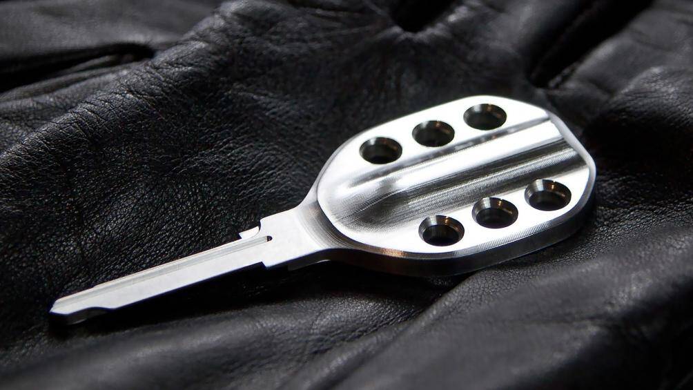 Chìa khoá này của Porsche 911 được làm bằng loại thép không gỉ 303. Ngoài ra, trên mặt chiếc khóa còn có 6 lỗ tròn, tượng trưng cho khối động cơ V6 thẳng hàng