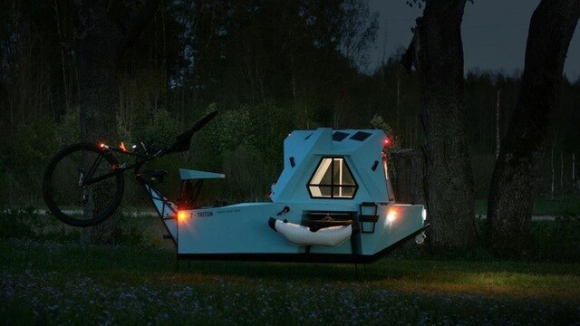 Xe có bánh trước lớn, hai bánh sau nhỏ hơn, khung lưới mắt cáo phía trước và một thùng nhà phía sau