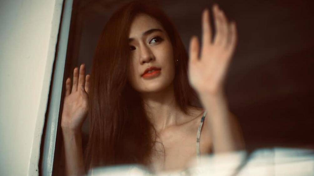 Người đẹp hờ hững ngắm nhìn cảnh vật xung quanh từ trên cửa sổ tàu hỏa