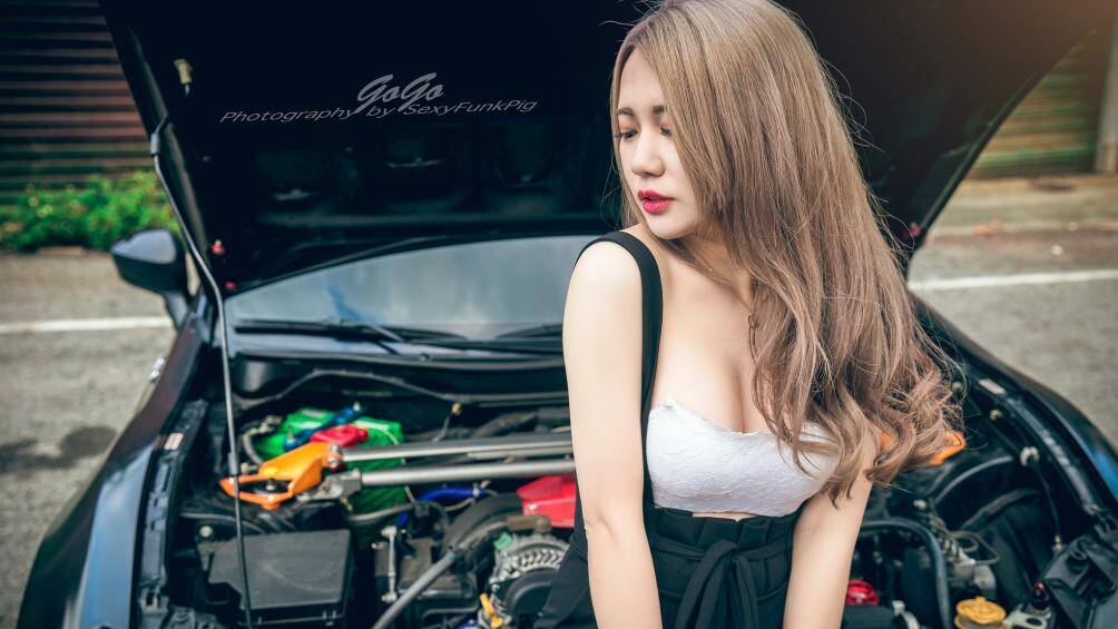 Khuôn mặt xinh đẹp cùng làn da trắng ngần trước khoang động cơ của chiếc xế sang