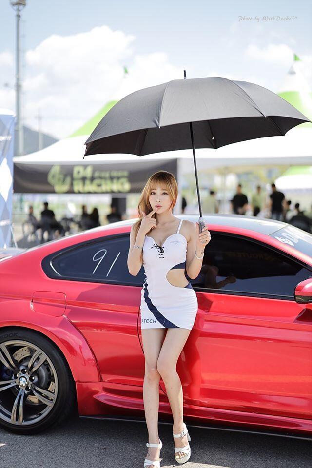 Vẻ đẹp kiêu kỳ như nổi bật hơn khi tạo dáng bên cạnh chiếc xe có màu sơn đỏ khỏe khoắn