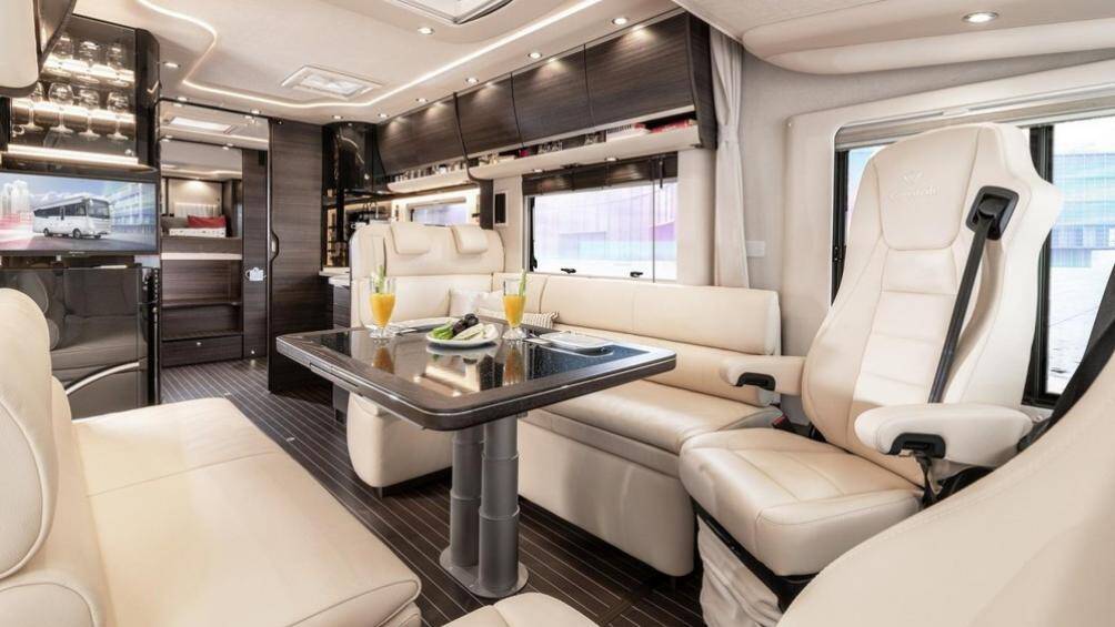 Khu vực sinh hoạt chính bên trong xe trông giống như một phòng khách gia đình với những chiếc ghế đệm êm ái và một cái bàn ở vị trí trung tâm