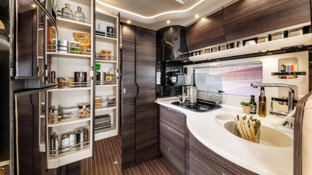 Khu vực bếp có đầy đủ trang bị với bếp ga, bồn rửa thép không gỉ và một tủ lạnh, máy rửa chén bát...