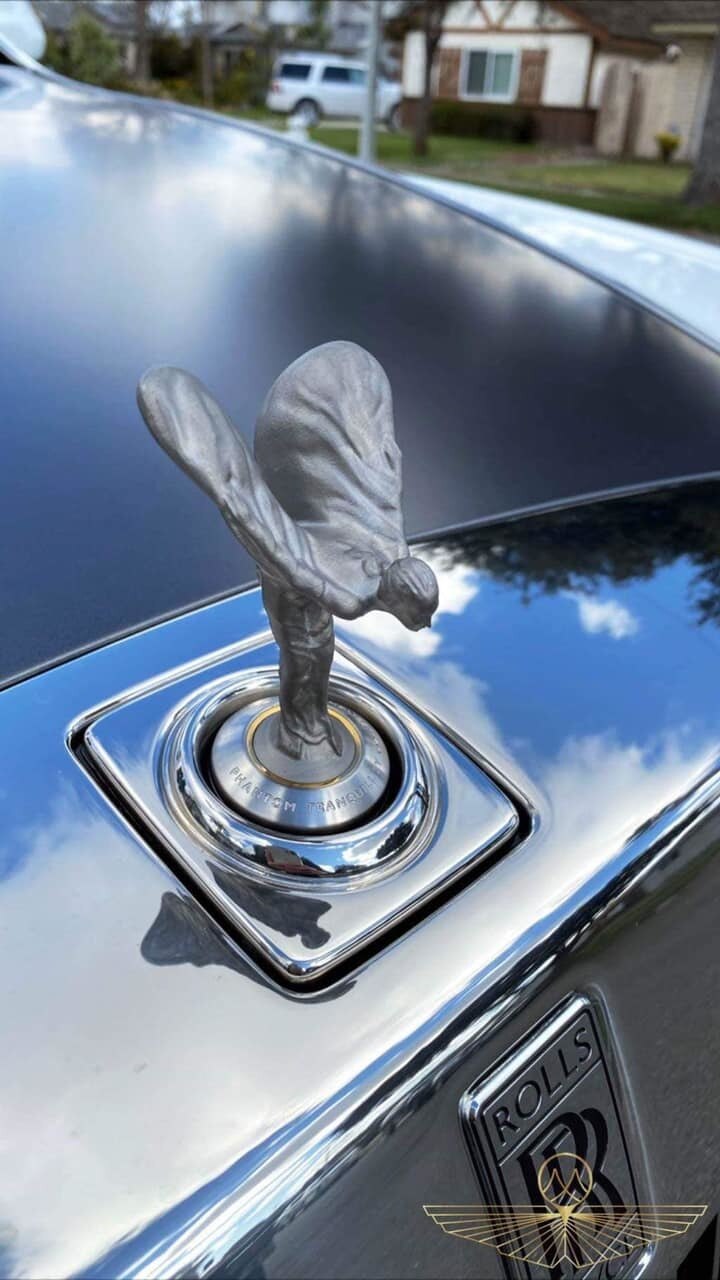 Biểu tượng Spirit of Ecstasy của xe bằng chất liệu titan màu tối và dưới chân logo này là tên phiên bản xe in dập nổi