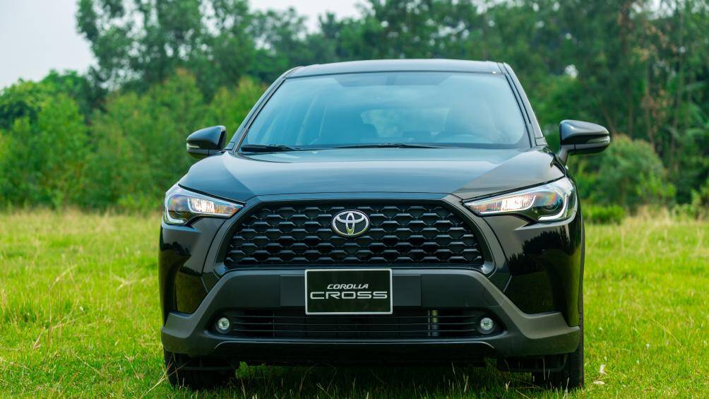 Ở phần đầu xe, Corolla Cross 1.8G phân biệt với 2 bản cao cấp hơn nhận thấy rõ nhât ở lưới tản nhiệt không có thanh mạ crôm nối từ đèn vào logo. Thêm vào đó, do là phiên bản thấp nhất nên xe chỉ sử dụng đèn chiếu sáng xa và gần dạng halogen chứ chưa phải dạng LED. Nhưng đèn chiếu sáng trên Toyota Corolla Cross 1.8G cũng được điều khiển tự động, gương chiếu hậu chỉnh, gập điện tích hợp đèn LED báo rẽ