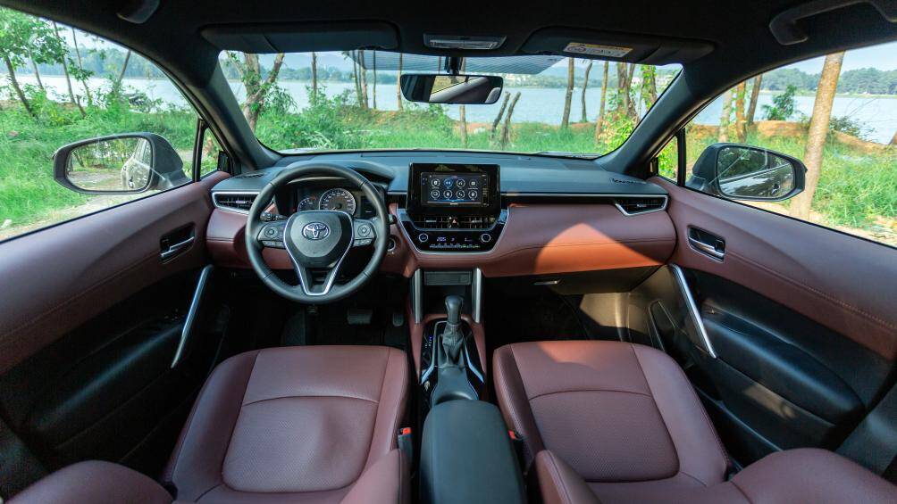 Khoang nội thất Corolla Cross 1.8G thiết kế hiện đại, với chất liệu da và nhựa giả da là chủ yếu. Ghế lái chỉnh điện 10 hướng, gương chiếu hậu trong xe chống chói tự động, các cửa kính lên xuống một chạm và chống kẹt, điều hòa tự động, đi kèm cửa gió hàng ghế sau