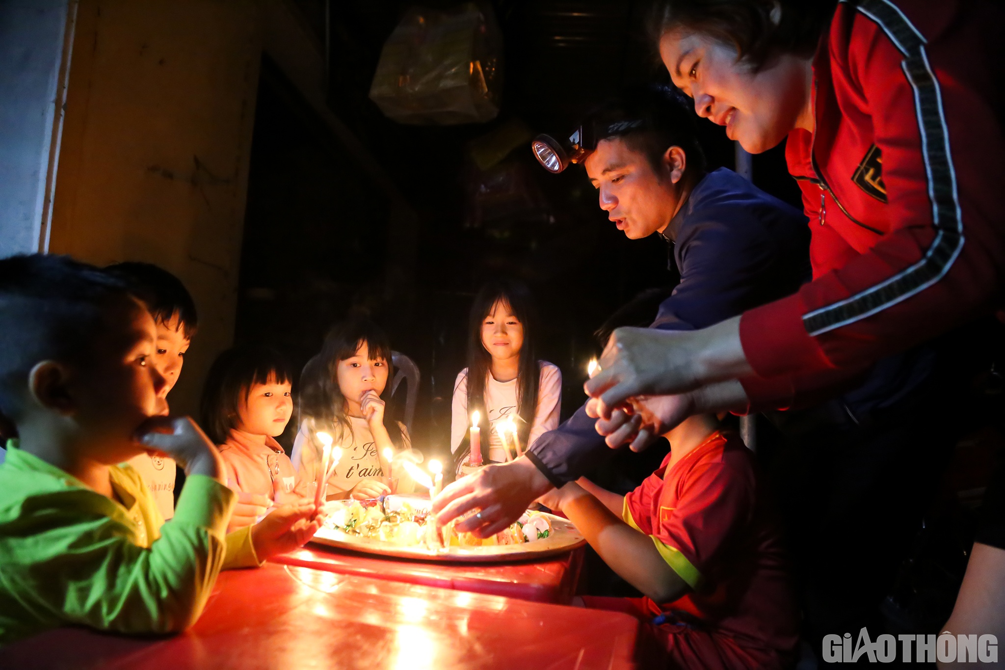 Dù nước lũ còn ngập trắng bốn bề, điện mất nhưng em Nguyễn Thị Thùy Trang (10 tuổi, tóc dài, ngồi giữa ở thôn Đông Nam Lí, xã Cẩm Bình) vẫn được bố mẹ và gia đình tổ chức sinh nhật cho.
