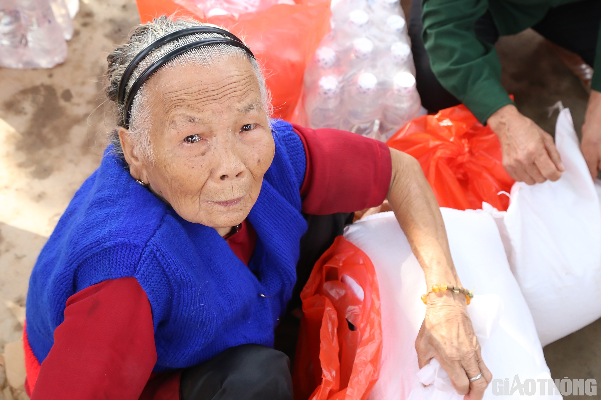 Cụ bà Lê Thị Đìa (90 tuổi, ở thôn Đông 2, xã Hiền Ninh ngân ngấn nước mắt khi đón nhận các món quà của Báo Giao thông và nhà tài trợ.